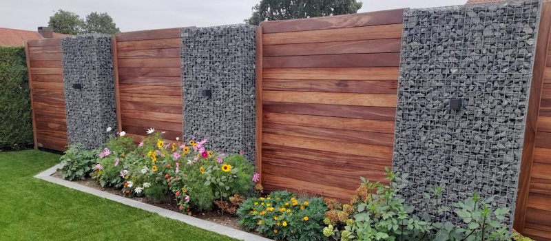 Steenkorven afgewisseld met houten panelen brengen warmte aan uw schutting.