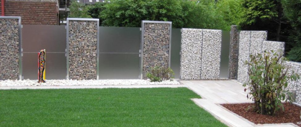 Schanskorven op een rijtje in een tuin geplaatst door een hovenier