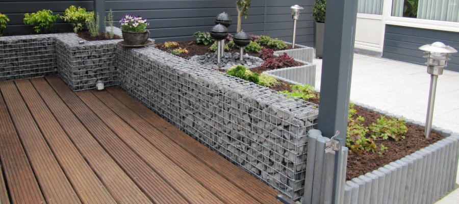 Creëer een stijlvolle tuin met steenkorven op maat. Steenkorven gebruikt als verhoogde plantenbakken en decoratie op een terras.
